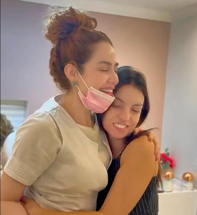 Michelle e uma cliente sorrindo em um abraço na Cristal Estética